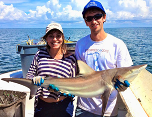 Alex Harper and Cheston Peterson, a Ph.D. Marine Biology student, show off an Atlantic sharpnose shark (Rhizoprionodon terraenovae) while conducting research as part of the NOAA Gulf Shark Pupping and Nursery (GulfSPAN) Survey. (Photo credit: Dean Grubbs)
