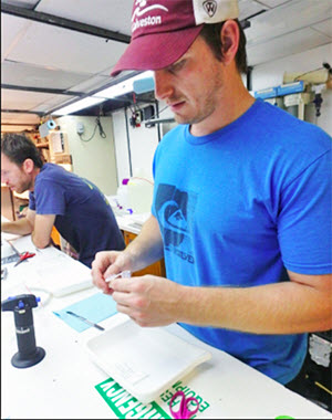 Max removes tissue from a fish for future genetic analysis aboard the RV Point Sur. (Provided by Max Weber)