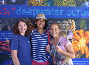 Graduate student Fanny Girard (left) joins game-day fans at the ECOGIG-II Ocean Discovery Zone. The coral banner makes a beautiful photo backdrop! (Photo by ECOGIG-II)